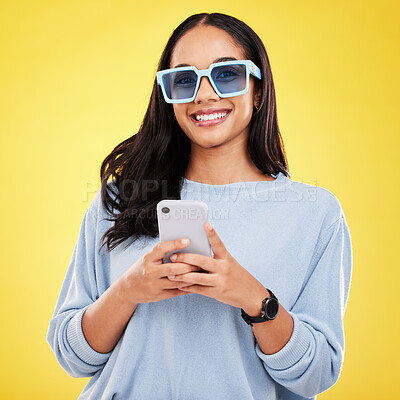 Buy stock photo Phone, smile and portrait of woman with sunglasses in yellow studio for social media, website and internet. Communication, mockup space and happy girl on  smartphone for chat, message and network