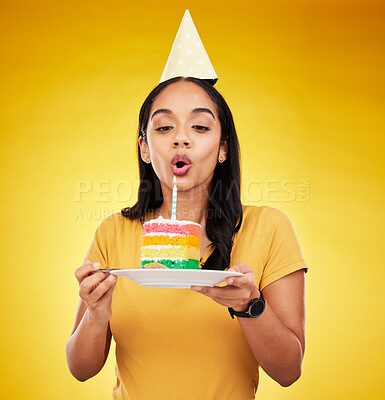 Buy stock photo Woman, birthday cake and celebration, blow out candle with  rainbow dessert isolated on yellow background. Celebrate, festive and young female, making a wish with sweet treat and party hat in studio