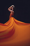 Fashion, woman and elegant with beauty on dark background, portrait and model in orange dress in studio. Indian female, glamour and stylish ballgown with sexy person, luxury style and designer wear