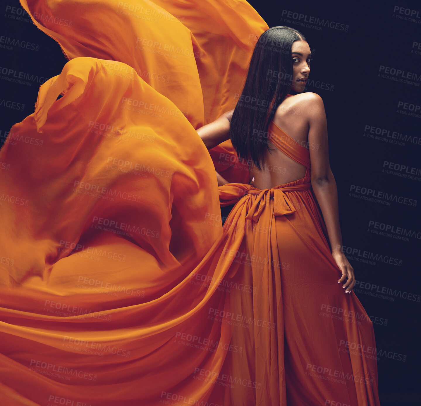 Buy stock photo Fashion, portrait and woman in orange dress in studio isolated on a black background. Beauty, aesthetics and confident Indian female model with glamour, stylish and wind, trendy or designer ballgown.