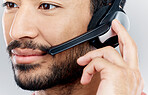 Man, face and headset for call center, telemarketing or online customer service against gray studio background. Closeup of male consultant with headphones and mic for wireless communication or advice