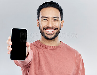 Buy stock photo Asian man, portrait smile and phone mockup for advertising or marketing against a white studio background. Happy male smiling with smartphone screen or display for mobile app advertisement or brand