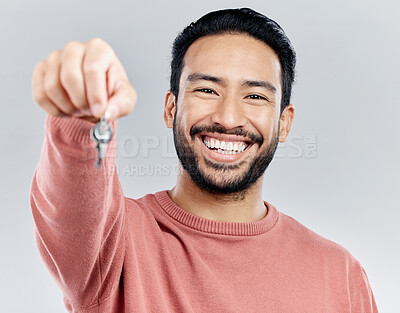Buy stock photo Key, real estate and smile with portrait of man in studio and giving you property, new homeowner or achievement. Rent, pride and purchase with male on white background for house, tenant or investment