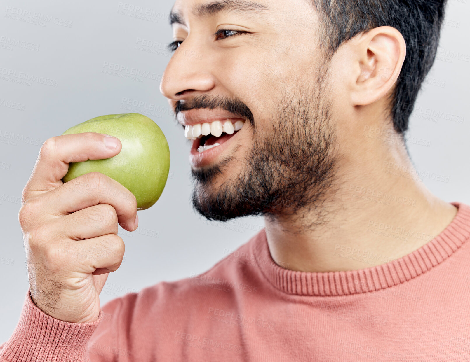 Buy stock photo Enjoying, happy and an Asian man eating an apple isolated on a white background in a studio. Smile, food and a Chinese guy taking a bite from a fruit for nutrition, diet or hungry on a backdrop