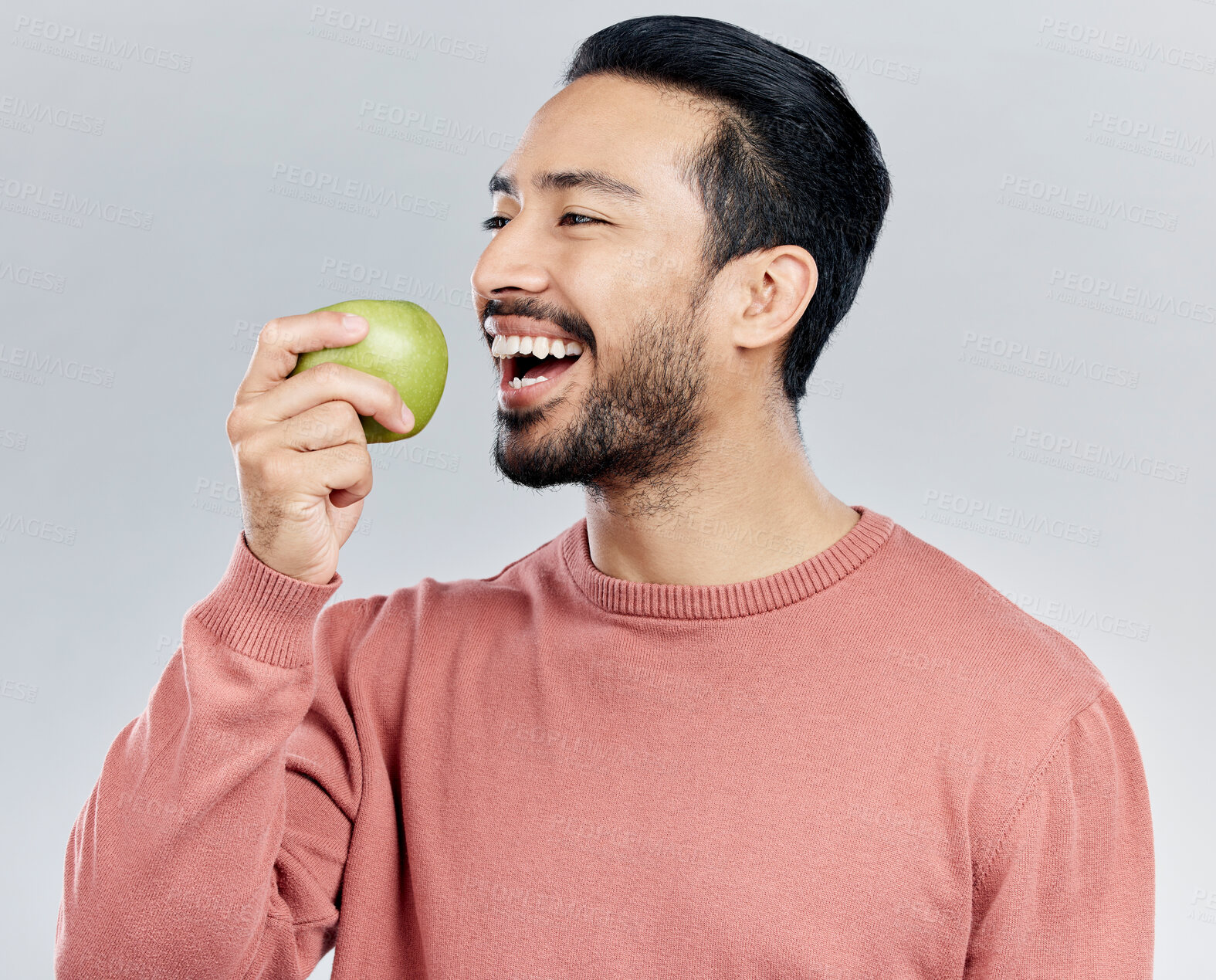 Buy stock photo Healthy, happy and an Asian man eating an apple isolated on a white background in a studio. Smile, food and a Chinese guy taking a bite from a fruit for nutrition, diet or hungry on a backdrop