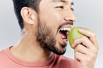 Buy stock photo Man is eating apple, health and nutrition with fruit, diet with healthy food and wellness on studio background. Closeup, vegan male and detox with weight loss, healthcare and organic fruits 