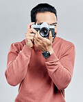 Man with camera, photography and artist, taking picture with art isolated on gray background. Photographer, focus with lens and creativity with vintage technology and creative male in studio