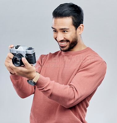 Buy stock photo Camera, photography and happy with asian man in studio for photoshoot, satisfaction and creative. Vintage, photographer and production with male on white background for shooting, lens and hobby