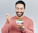 Man, salad food and eating healthy in studio for health or wellness motivation for vegetables. Asian male happy with vegetable for nutrition, diet and benefits to lose weight on a white background