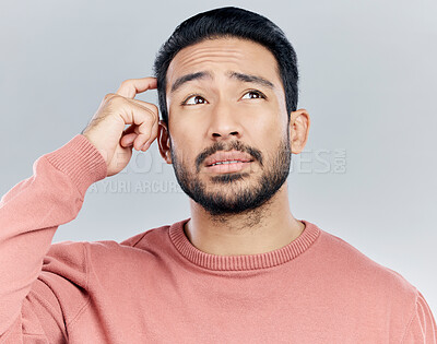 Buy stock photo Thinking, confused and doubt with a man in studio on a gray background looking thoughtful or contemplative. Question, idea and memory with a young asian male trying to remember but feeling unsure