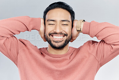 Buy stock photo Face, happy and silence with a man in studio on a gray background to cover his ears while enjoying quiet. Noise, smile and relax with a handsome young male blocking sounds with his hands for peace