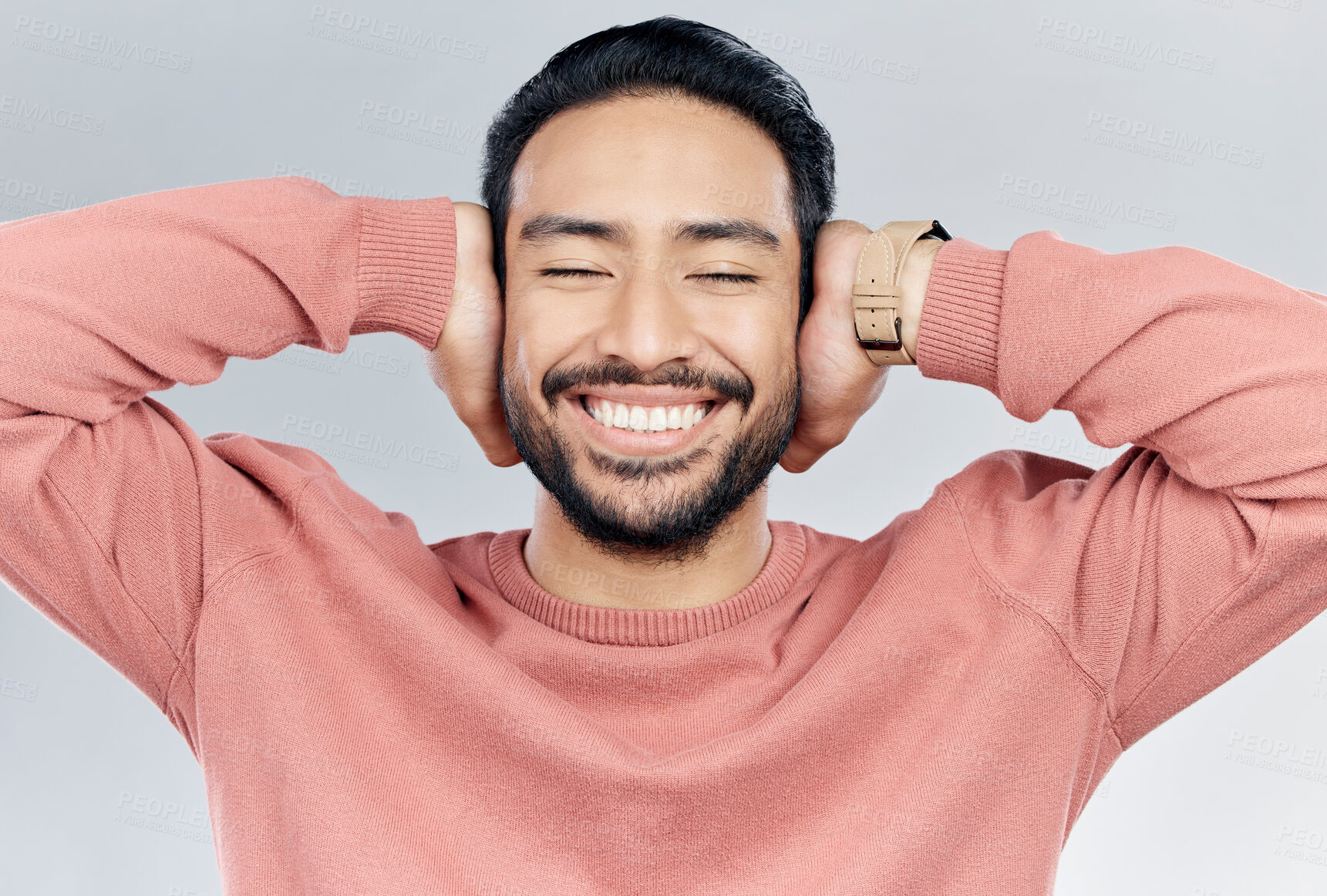 Buy stock photo Face, happy and silence with a man in studio on a gray background to cover his ears while enjoying quiet. Noise, smile and relax with a handsome young male blocking sounds with his hands for peace