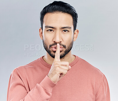 Buy stock photo Secret, finger on lips and portrait of man in studio with privacy, silence and confidential hand gesture. Communication mockup, emoji and face of male on grey background for shush, whisper or gossip