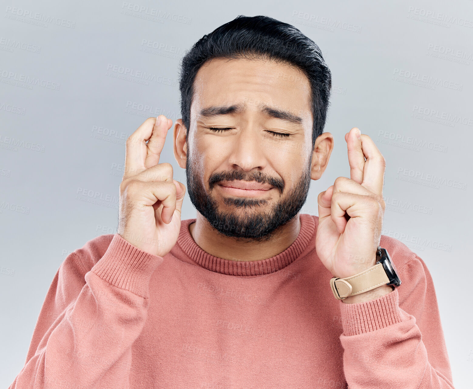 Buy stock photo Wish, fingers crossed and praying with man in studio for good luck, promotion and announcement. Lottery, winner and hope with male isolated on white background for nervous, worry and belief gesture