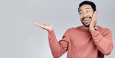 Buy stock photo Product placement, happy and an Asian man showing mockup isolated on a white background. Excited, looking and a guy gesturing to space for branding, advertising and marketing on a studio backdrop