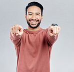 Pointing, selection and smile with portrait of man in studio for thank you, motivation and amazing. Winner, confident and friendly with male on white background for yes, achievement and satisfaction