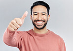 Portrait, great and Asian man with thumbs up, vote and happiness against a studio background. Face, Japanese male and guy with gesture for well done, promotion and agreement with smile and approval
