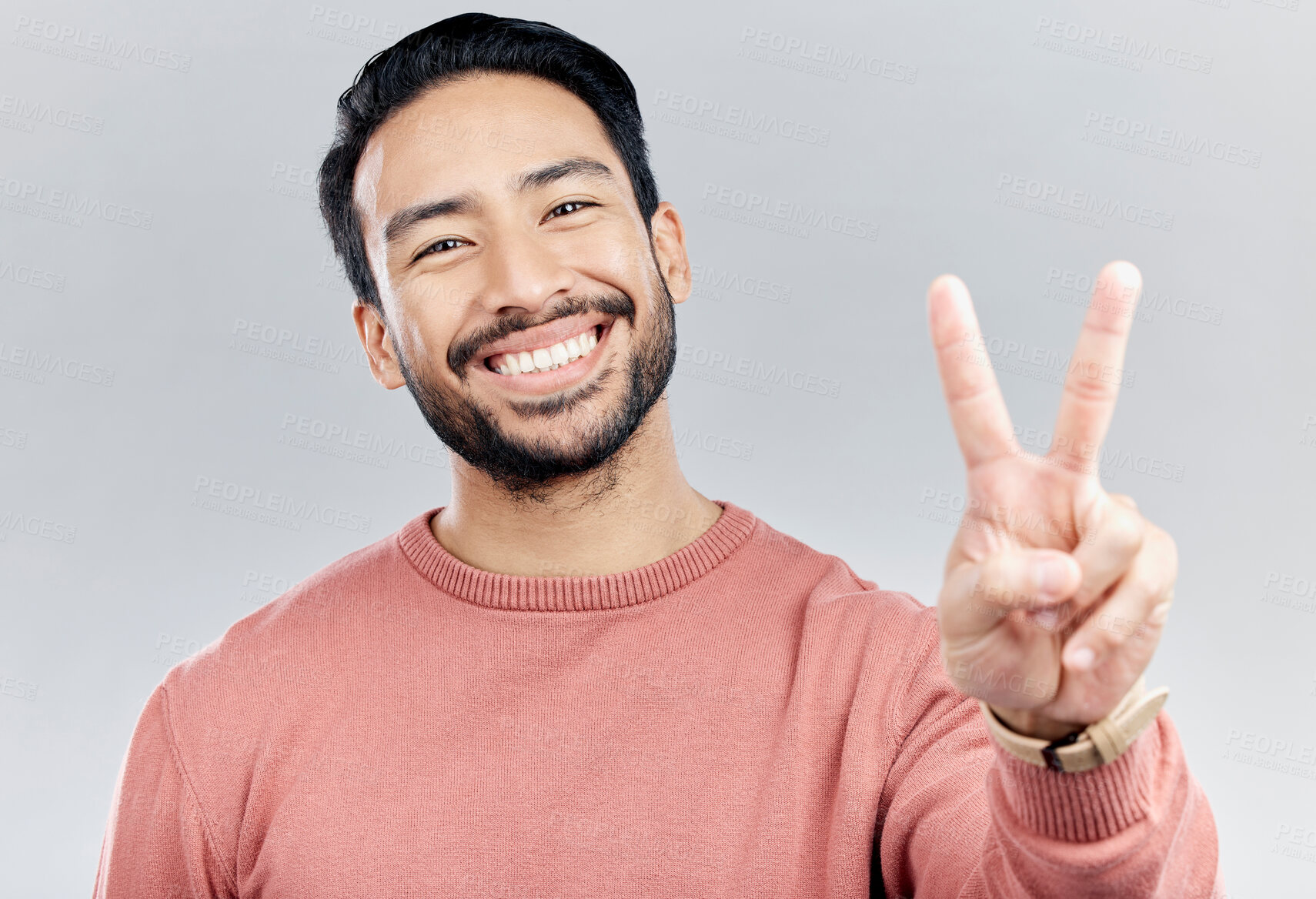 Buy stock photo Portrait, smile and Asian man with peace sign in studio isolated on a gray background. Face, v emoji and happy, smiling or excited, young and confident male model with hand gesture or peaceful symbol