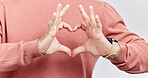 Hands, heart and man with love in studio to show support, thank you or charity sign language. Male model person with hand icon for kindness, care and hope review, motivation or emoji opinion feedback