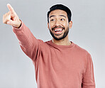 Mockup, smile and Asian man pointing, promotion and product placement against grey studio background. Japan, male and happy guy with gesture for direction, space and brand development with happiness