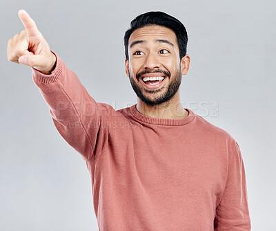 Buy stock photo Mockup, smile and Asian man pointing, promotion and product placement against grey studio background. Japan, male and happy guy with gesture for direction, space and brand development with happiness