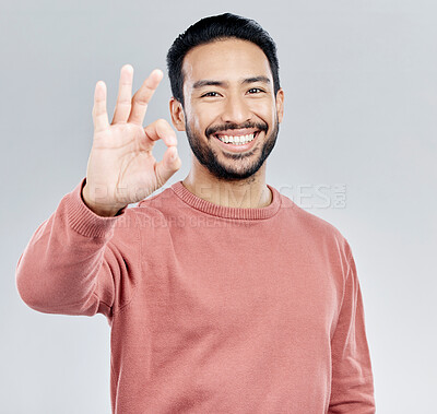 Buy stock photo Hand, portrait and okay sign by man in studio with yes, vote or approval gesture against grey background. Finger, emoji and perfect symbol by asian male happy with decision, thank you or satisfied 