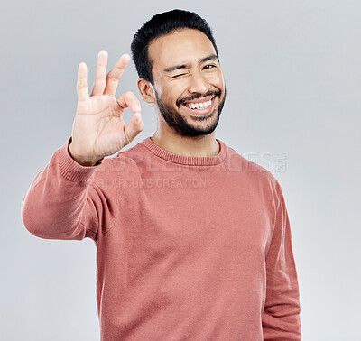 Buy stock photo Perfect, winking and portrait of an Asian man with a hand gesture isolated on a white background in studio. Ok, review and a flirty guy with a wink and emoji sign for satisfaction and happiness