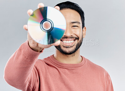 Buy stock photo Man, holding and compact disc in studio portrait for smile, happiness and technology by white background. Asian model, student and cd in hand for movie, audio and sound with happy, excited and tech