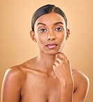 Serious, beauty and portrait of a woman with makeup isolated on a studio background. Wellness, lifestyle and an Indian model with cosmetics promotion, feminine and looking elegant on a backdrop