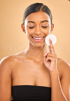 Buy stock photo Beauty, skin and face cotton of woman in studio for cosmetics, dermatology or makeup. Aesthetic female 
hand with product for self care, natural makeup and facial shine results on a brown background