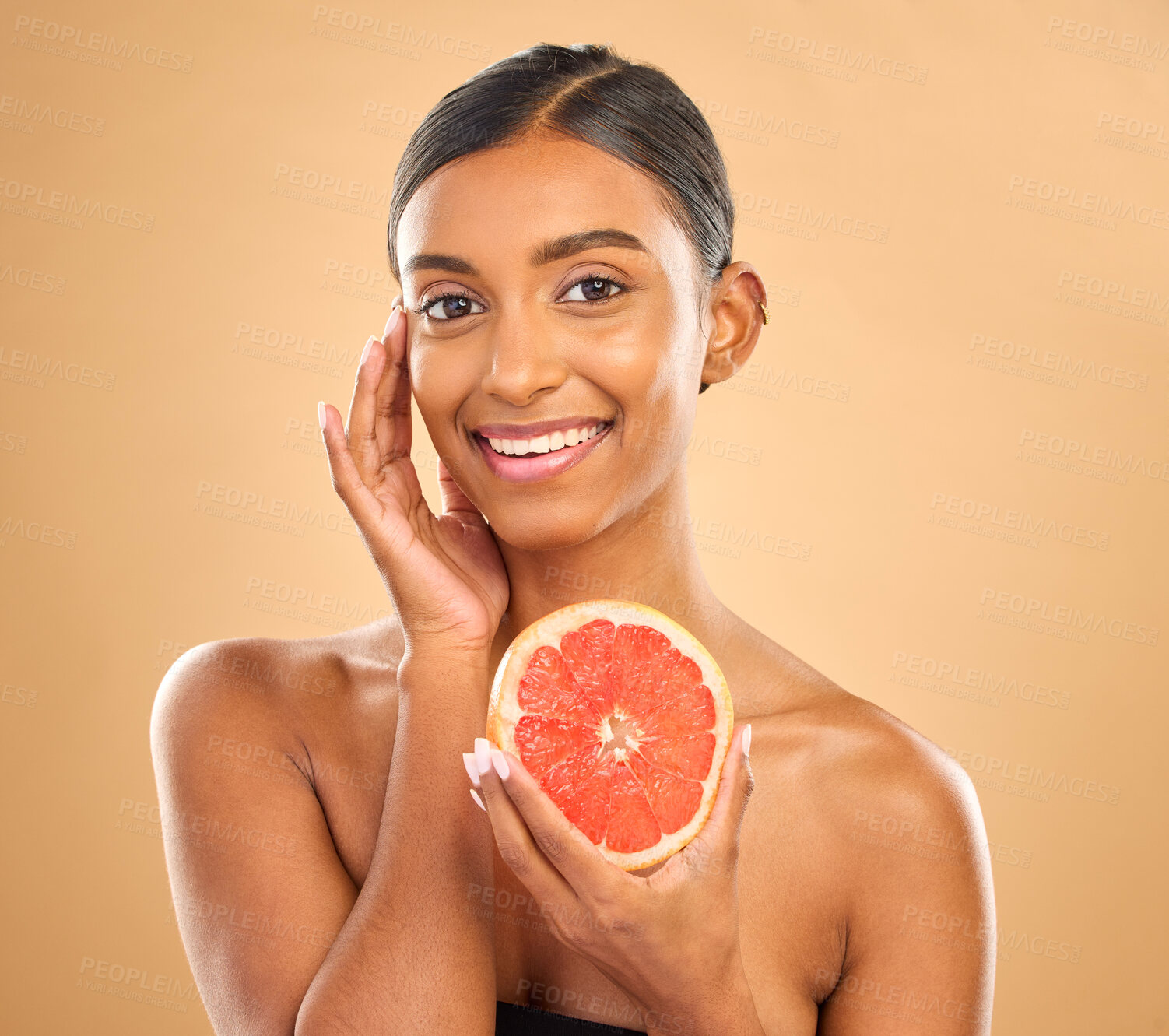 Buy stock photo Skincare, portrait and a woman with a grapefruit for a glow isolated on a studio background. Food, smile and an Indian model with a fruit for healthy skin, complexion and vitamin c treatment