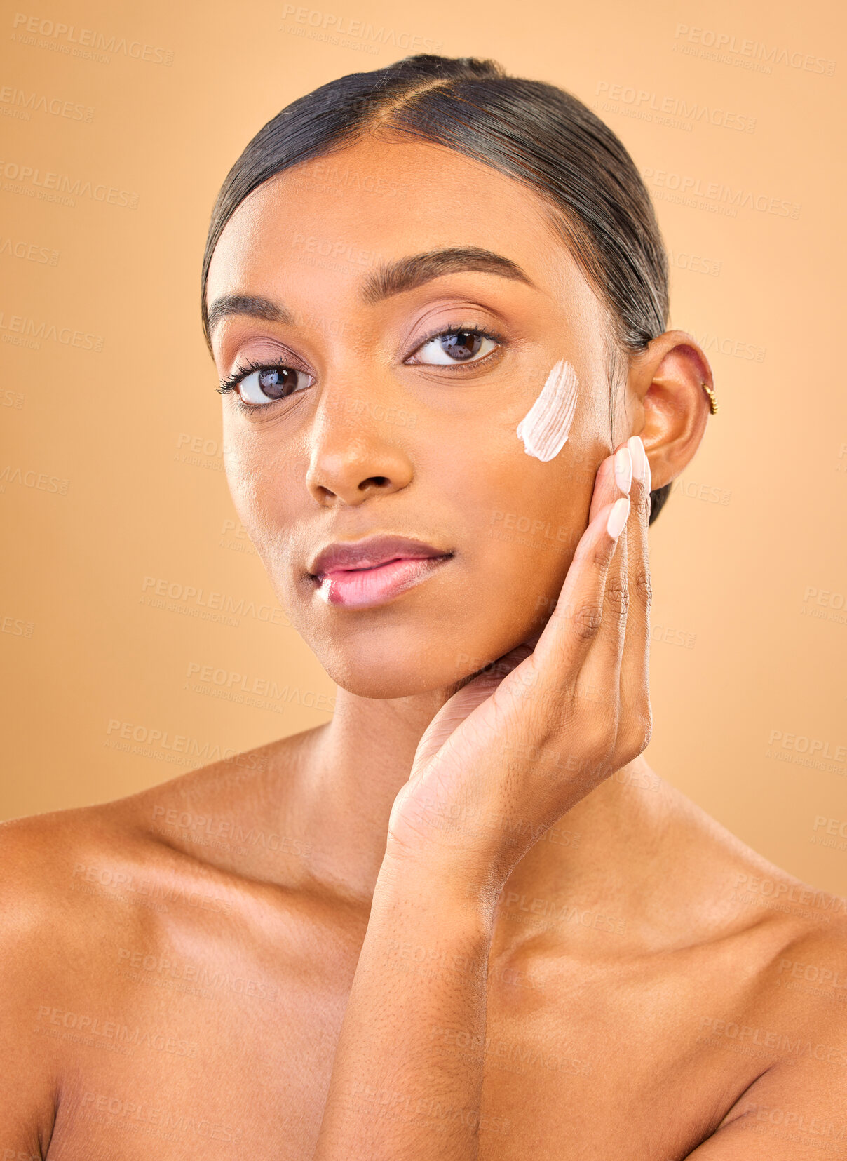 Buy stock photo Face portrait, skincare and woman with cream in studio isolated on a brown background. Dermatology, cosmetics or confident Indian female model with lotion, beauty creme or moisturizer for skin health