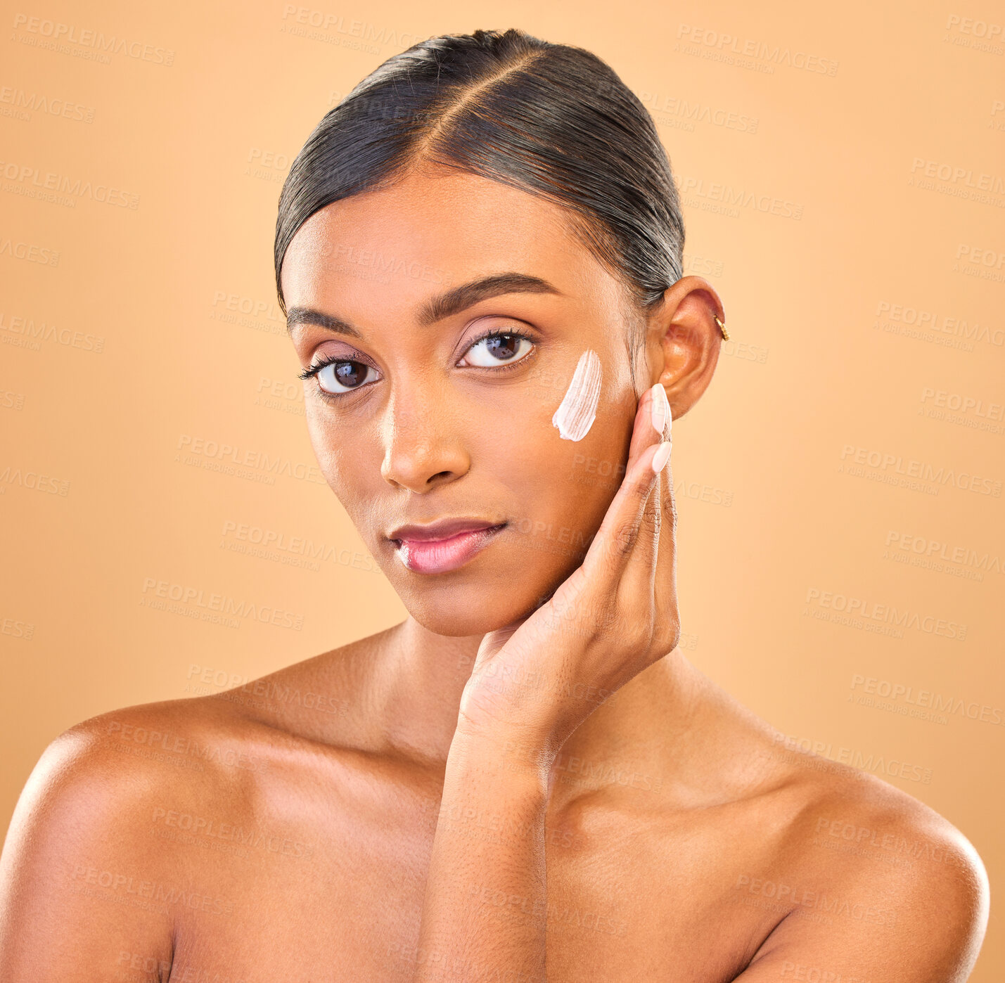 Buy stock photo Face portrait, skincare and woman with cream in studio isolated on a brown background. Dermatology, cosmetics or confident Indian female model with lotion, beauty creme or moisturizer for skin health