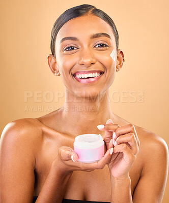 Buy stock photo Face, skincare and woman with cream jar in studio isolated on a brown background. Dermatology cosmetics, portrait and happy Indian female apply lotion, creme and moisturizer product for healthy skin.