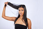 Hair damage, breakage and portrait of a frustrated woman isolated on a white background in studio. Bad, unhappy and an Indian girl sad about split ends, tangled hairstyle and frizzy haircare