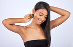 Woman brush hair, beauty and haircare with cosmetics, keratin treatment and smile on studio background. Happy, Indian female with straight hairstyle and skin glow, Brazilian and cosmetic care