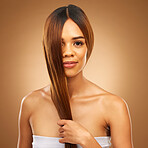 Haircare, smile and portrait of woman in studio holding strong hair in hand with texture and shine. Happy model, mockup and beauty, healthy straight hairstyle with keratin product on brown background