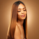 Beauty, hair care and face of woman in studio for growth and color shine or healthy texture. Aesthetic female model for haircare, natural makeup glow and hairdresser or salon on a brown background
