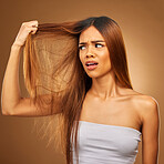 Hair, problem and woman in studio frustrated with hair loss, split ends or damage against a brown background. Haircare, crisis and girl model with knot, messy and annoyed with salon results isolated