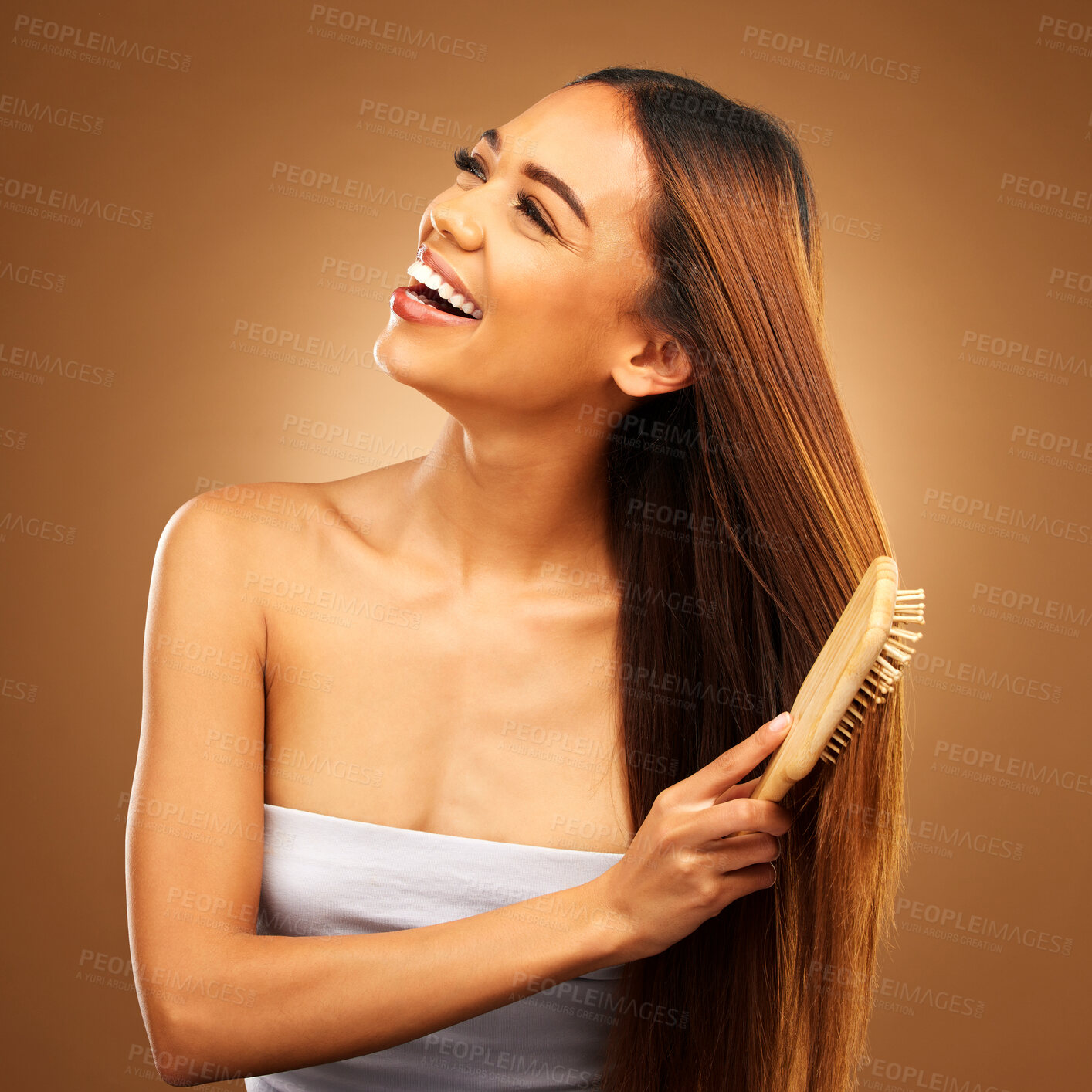 Buy stock photo Brushing hair, beauty and a happy woman in studio for growth and color shine or healthy texture. Aesthetic female smile for brush, natural haircare and hairdresser or salon on brown background
