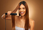 Hair care, beauty and portrait of woman with flat iron and smile for luxury salon treatment tool on brown background. Beauty, electric straightener and happy model with straight hairstyle in studio.