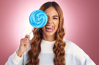 Buy stock photo Portrait, funny face and lollipop with a woman in studio on a pink background holding giant candy. Comic, comedy and sweet with a playful young female feeling silly while eating a blue sugar treat 