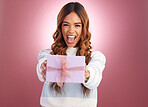 Woman, present and box in studio portrait with giving surprise, happy or celebration by gradient background. Student girl, young or happiness with gift package, excited face or celebrate for giveaway