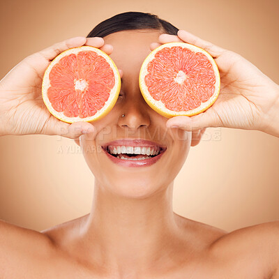 Buy stock photo Beauty face, laugh or happy woman with grapefruit for fruit detox, healthcare or natural facial skincare routine. Vitamin c food product, fun studio or playful female nutritionist on brown background