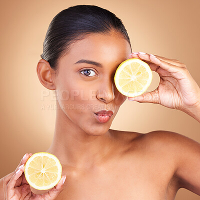 Buy stock photo Indian woman, beauty and skincare with lemon in studio for health, wellness or fruit by brown background. Asian model girl, young or happy with natural citrus fruits for health, cosmetic or skin glow