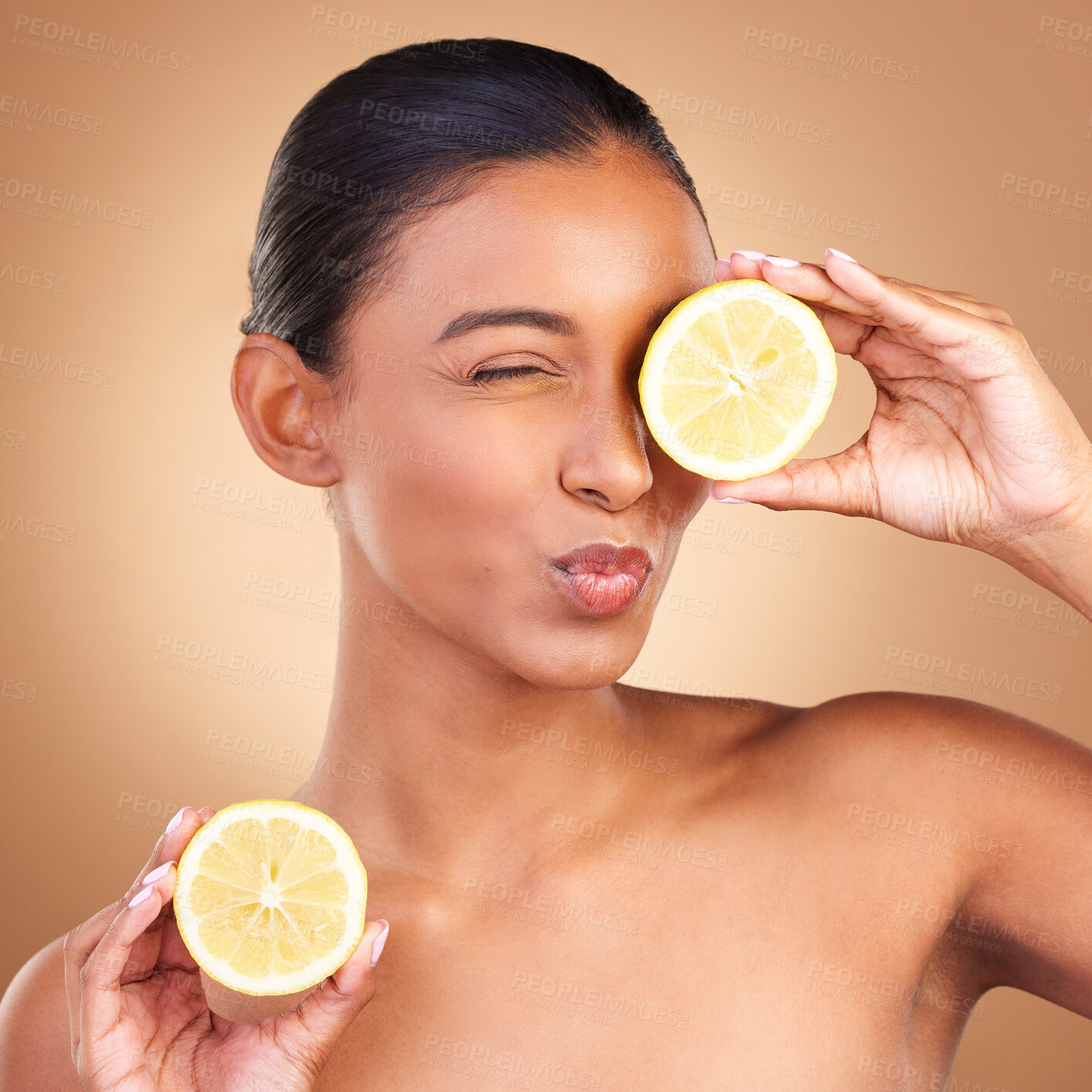 Buy stock photo Indian woman, skincare and lemon in studio with health, wellness or fruit treatment by brown background. Asian model girl, young and happy with organic citrus fruits for health, cosmetic or skin glow