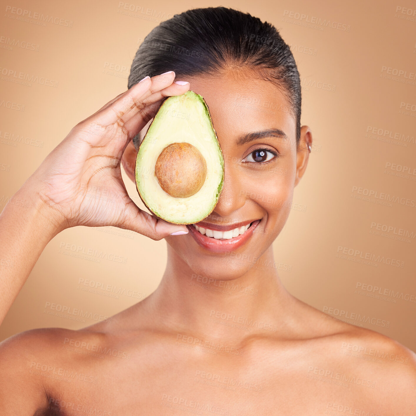 Buy stock photo Indian woman, avocado and studio portrait for beauty, health and wellness with fruit by brown background. Asian young model and girl with organic self care with fruits, healthy cosmetic and skin glow