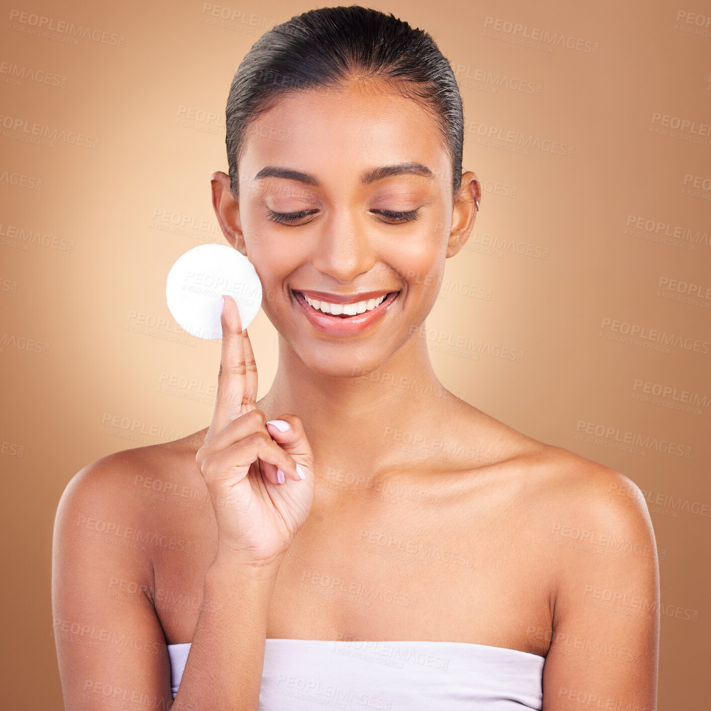 Buy stock photo Beauty, skincare and cotton with indian woman in studio for self care, makeup remover and cosmetics. Happy, clean and glow with face of model on brown background for results, natural and facial