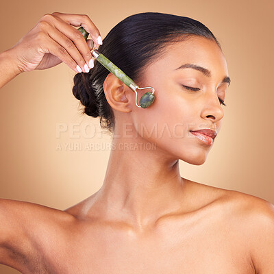 Buy stock photo Woman, beauty and derma roller with face, calm with facial massage and skincare on studio background. Cosmetic tools, healthy skin glow and female with eyes closed, jade quartz and crystal with peace