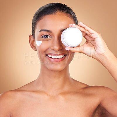 Buy stock photo Indian woman, skincare cream and jar in portrait with smile, happiness and wellness by brown background. Happy model, lotion product and face in studio for dermatology, aesthetic and cosmetic beauty